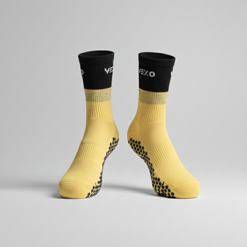 Yellow socks with black tops and sole pattern on a gray background
