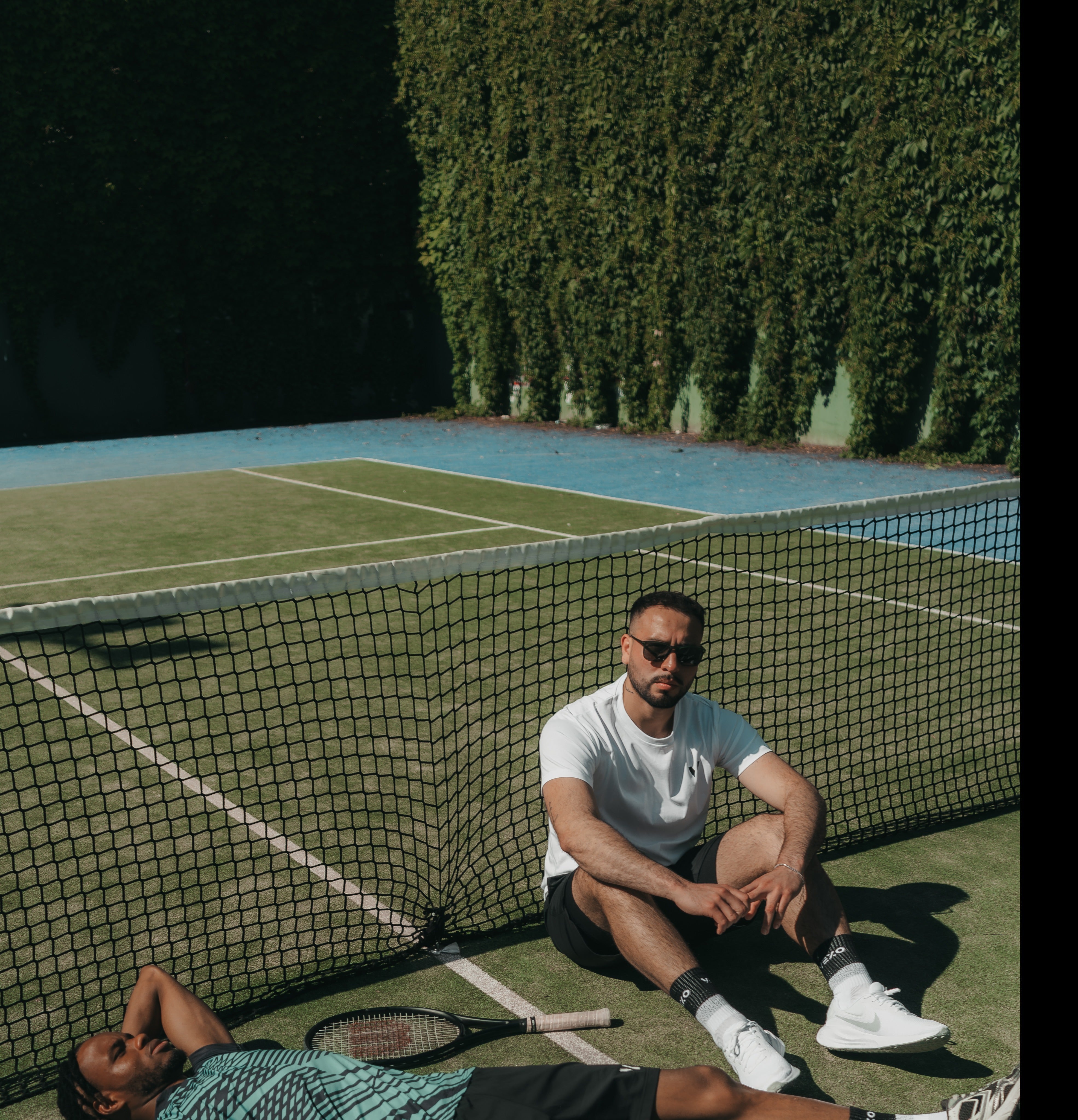 Vexo players on a court, sitting by the net during a photoshoot