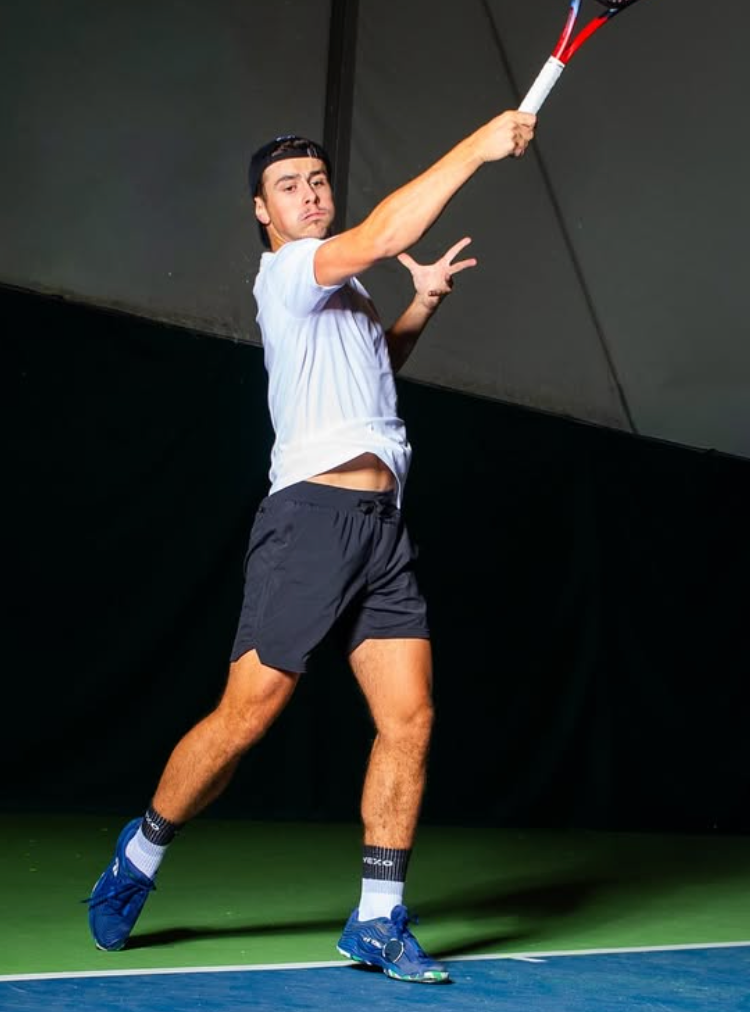 Player wearing the Vexo TrainWell Training T-Shirt — lightweight, moisture-wicking indoor tennis clothing for the European indoor season