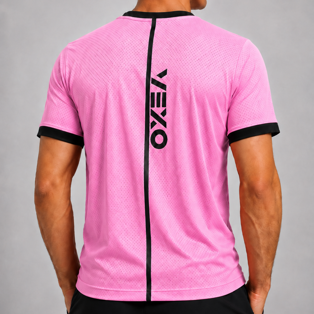 A man viewed from the back wearing a pink athletic t-shirt with black trim and a vertical black 'VEXO' logo on the back, paired with black shorts against a gray studio background.
